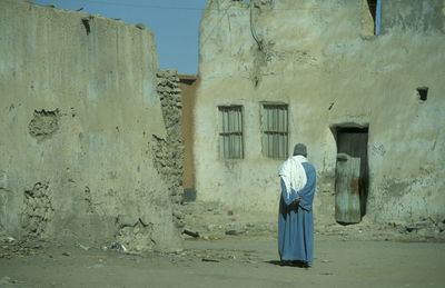 Rear view of woman standing against rock formations