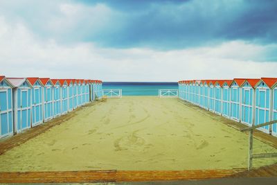 Pier on beach against sky