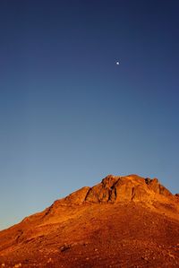 Low angle view of mountains against clear blue sky