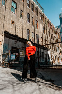 Full length of woman standing against building in city