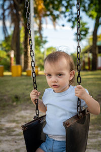 Close-up of cute boy on swing at playground