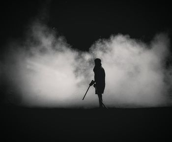 Rear view of man standing amidst smoke 