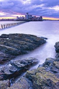 A long exposure of knightstone island, the causeway and marine lake at sunset with a high tide.
