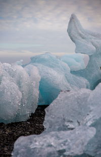 Close-up of glacier in water against sky