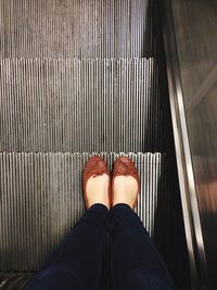 Woman standing on a escalator 