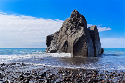 Scenic view of rock on beach against sky