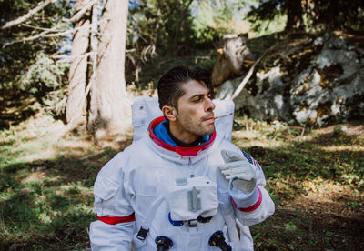 Astronaut smoking in forest