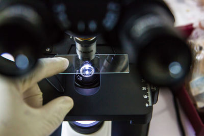 Cropped hand with microscope in laboratory