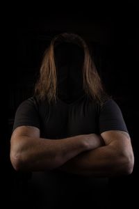 Midsection of man standing against black background