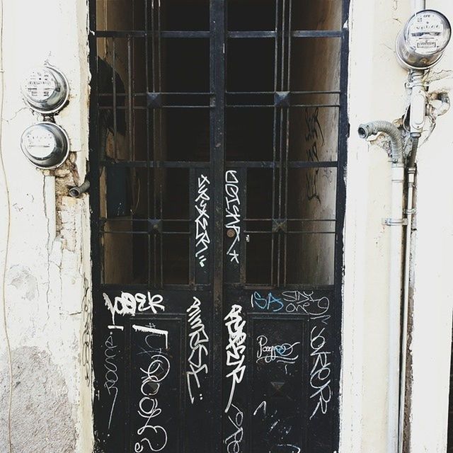 wall - building feature, built structure, architecture, door, metal, wall, closed, building exterior, graffiti, old, hanging, no people, day, close-up, safety, window, security, protection, outdoors, house