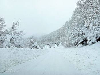 Snow covered landscape against sky