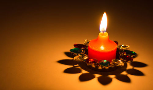 Close-up of lit candle on table