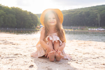 Portrait of young woman sitting at beach