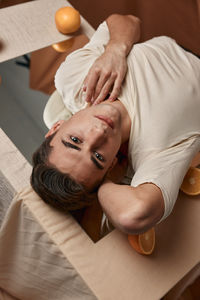 High angle portrait of man relaxing on bed at home