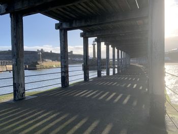 Bridge over river against sky on sunny day