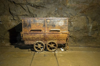 Old rusty wheel against wall