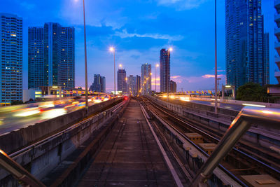 Light trails on city buildings against sky at night