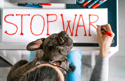 Man and french bulldog dog writing anti-war banner