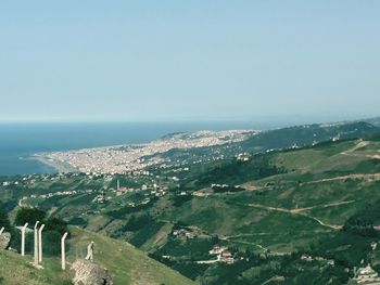 Aerial view of landscape and sea against clear sky