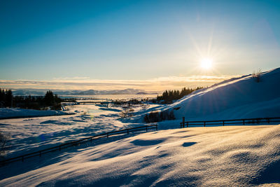 Scenic view of snow covered mountains against sky during sunset