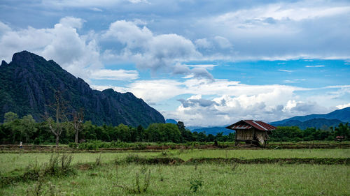 Scenic view of field and mountains against sky