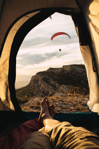 Low section of woman relaxing under tent