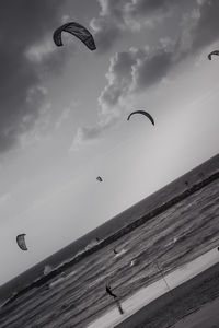 Low angle view of kite flying over sea against sky