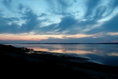 Reflection of clouds in sea at sunset