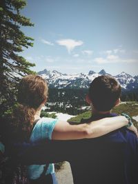 Rear view of friends against mountains during winter