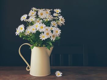 Close-up of white flower vase on table against black background