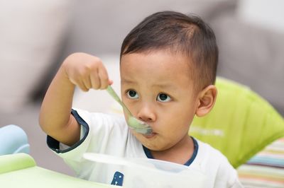 Cute baby boy eating from spoon