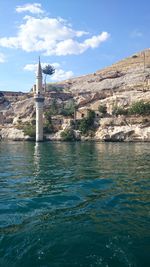 Scenic view of sea by buildings against sky