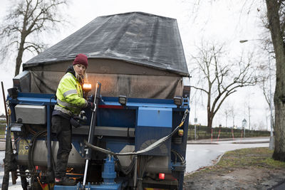 Young female construction worker operating machinery