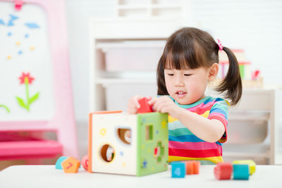 Cute girl playing with toy at home