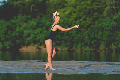 Full length of woman standing by lake