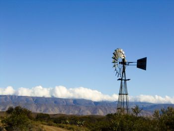 Low angle view of windmill on field against sky