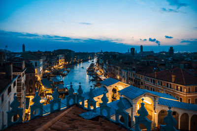 High angle view of illuminated city against sky at dusk