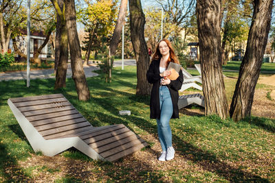 Choosing a university, college. female college student with books and laptop outdoors. redhead