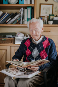 Senior man looking at photo album at home