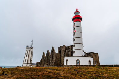 Low angle view of lighthouse on building against sky