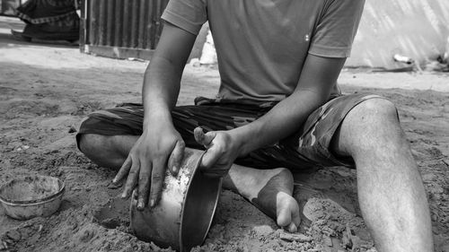 Midsection of man sitting on floor
