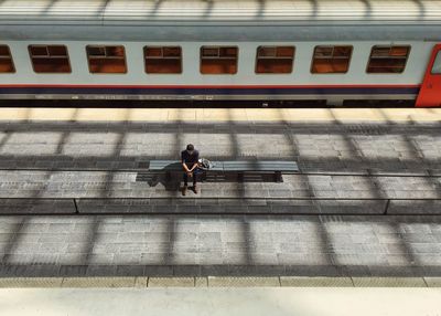 High angle view of man sitting at railroad station platform