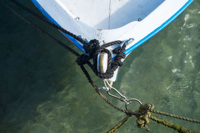 High angle view of boat tied up with ropes moored on sea