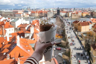 High angle view of hand holding buildings in city
