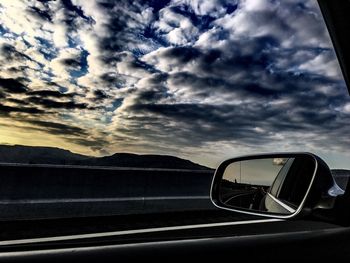 Reflection of cloudy sky on road