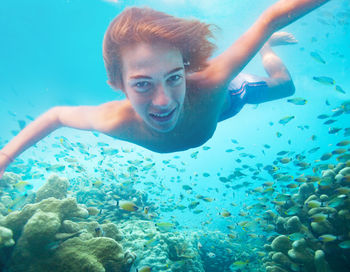 Portrait of young woman swimming in sea