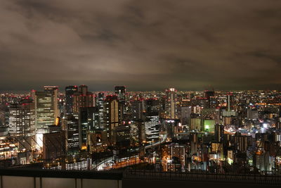 Illuminated cityscape against sky at night