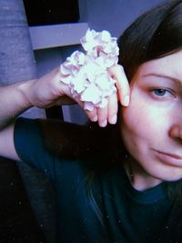 Close-up portrait of woman holding pink flower