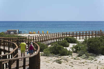 Man standing by railing against sea