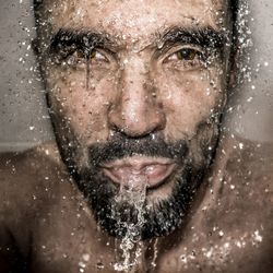 Close-up portrait of mature man spitting water